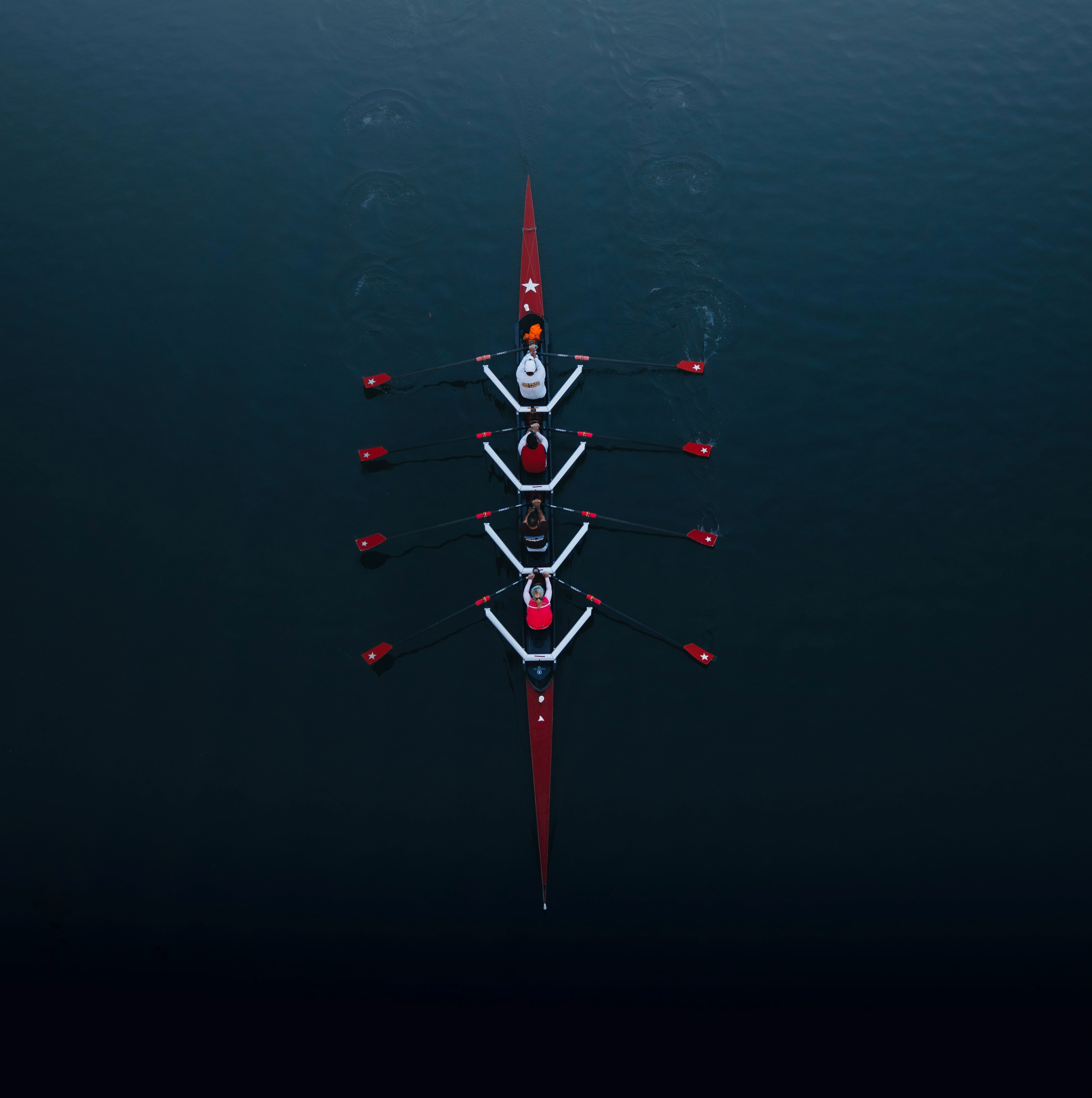 Eight-person crew rowing in unison at sunrise